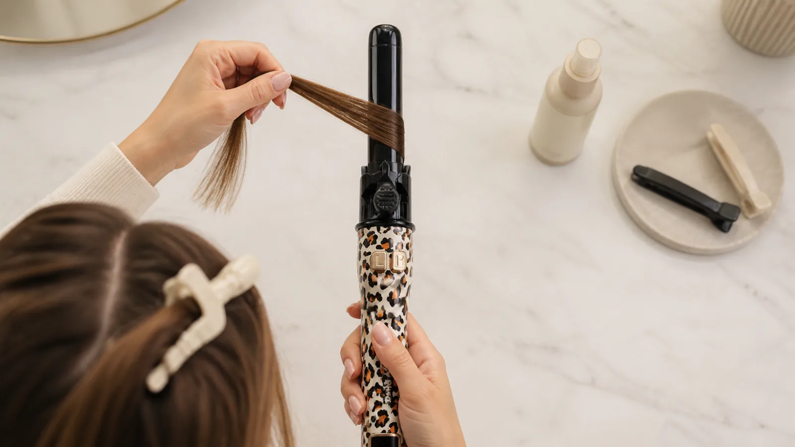 Vertical automatic rotating curling iron ready to feed a slim dry hair section